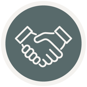 Icon of two hands shaking on a gray circular background, symbolizing the trusted partnership you can expect with a design-build contractor or home builder in Eagle River, WI.