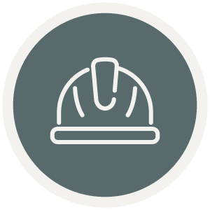 Icon of a hard hat in a circular frame with a gray background, symbolizing the expertise and reliability of a design-build contractor in Eagle River, WI.