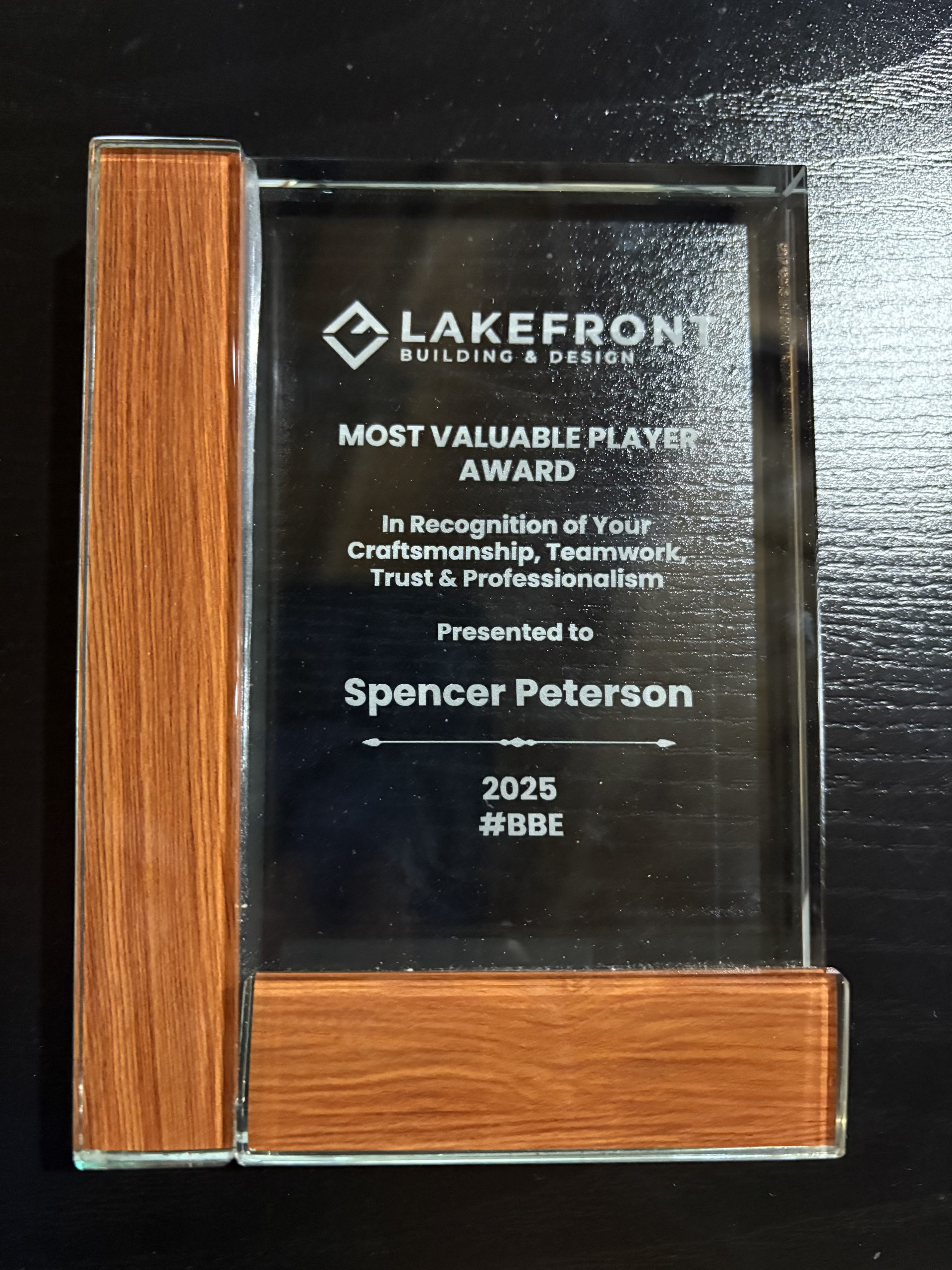 A glass award with wood accents presented to Spencer Peterson by Lakefront Building & Design for Most Valuable Player 2025.