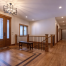Spacious foyer with wood flooring, front door with glass panels, a bench by a staircase, recessed ceiling lights, and design touches that complement custom tile showers throughout the home.